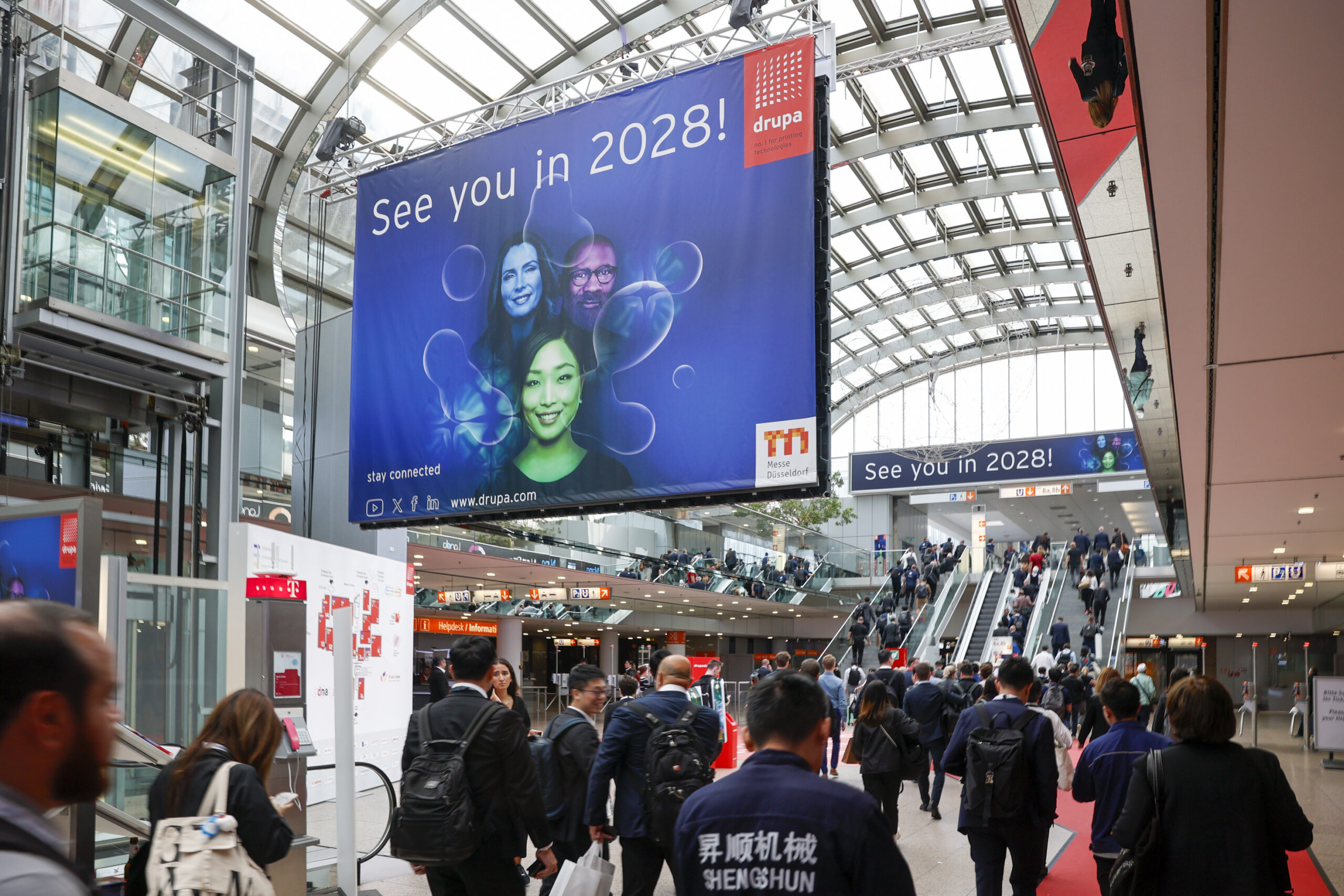 Vom 28. Mai bis 7. Juni trifft sich die internationale Printbranche auf der drupa 2024, der weltweit führenden Fachmesse für Drucktechnologien. Das Düsseldorfer Messegelände mit 18 Hallen ist komplett belegt. 1.646 Aussteller aus 52 Ländern präsentieren zukunftsweisende Innovationen und bahnbrechende Technologien aus der Print Media Industrie, industrial & functional printing bis hin zu packaging production. Dabei im Fokus: Die Megatrends Nachhaltigkeit und Digitalisierung.|
From 28 May to 7 June, the international printing industry will meet at drupa 2024, the world's leading trade fair for printing technologies. The Düsseldorf exhibition centre with its 18 halls is fully booked. 1,646 exhibitors from 52 countries will showcase groundbreaking innovations and cutting-edge technologies from the print media industry, industrial & functional printing and packaging production. The focus will be on the megatrends of sustainability and digitalisation.